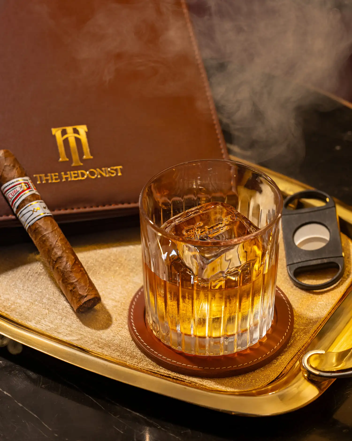 Whisky on tray with cigar and The Hedonist branding